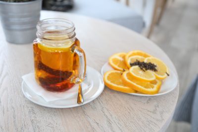Mug of tea with lemon and plate of sliced lemons and oranges