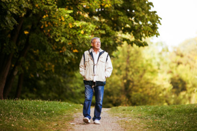 Retired aged man walking in park