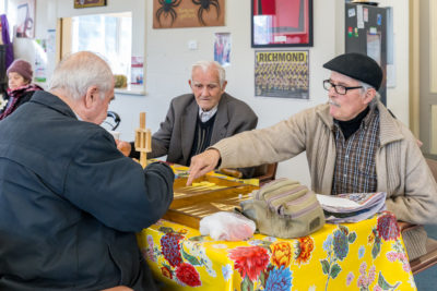 Men play board games at a social group meeting