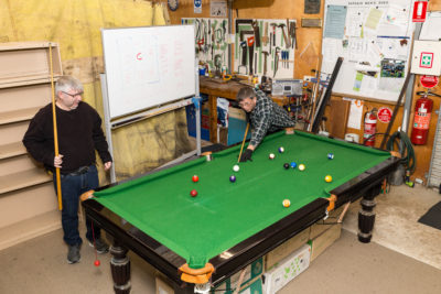 Men play pool in the shed