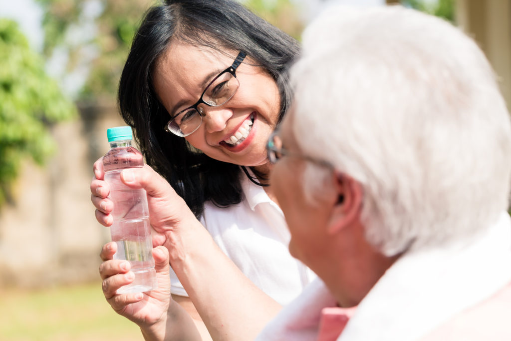 Friend gives older woman bottle of water