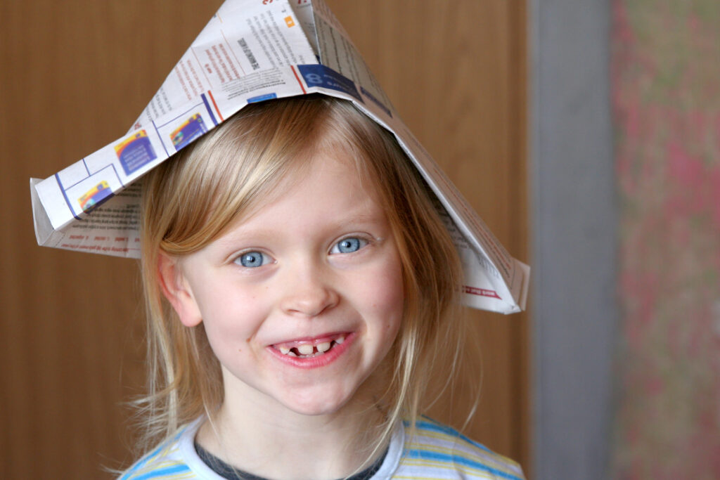 Girl wearing newspaper hat