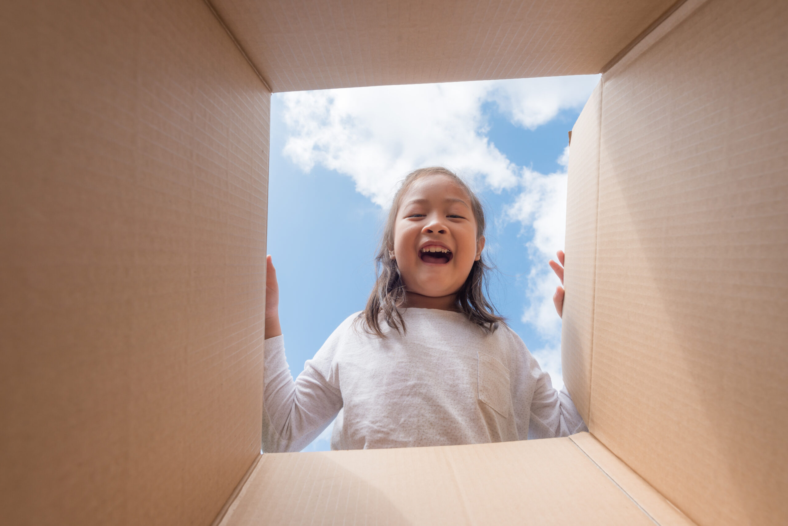Girl plays with cardboard box